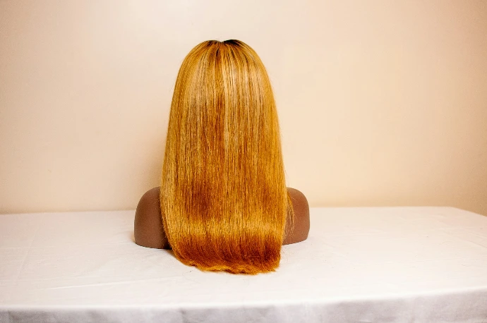 a woman's hair wig on a white surface